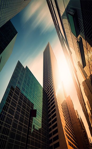 Tall glass office towers rising into a sunlit sky
